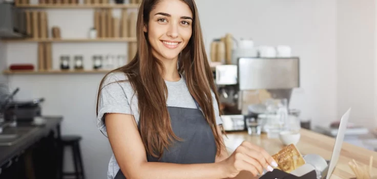 female coffee shop employee using credit card reader bill customer looking happy smiling camera 197531 22383 1
